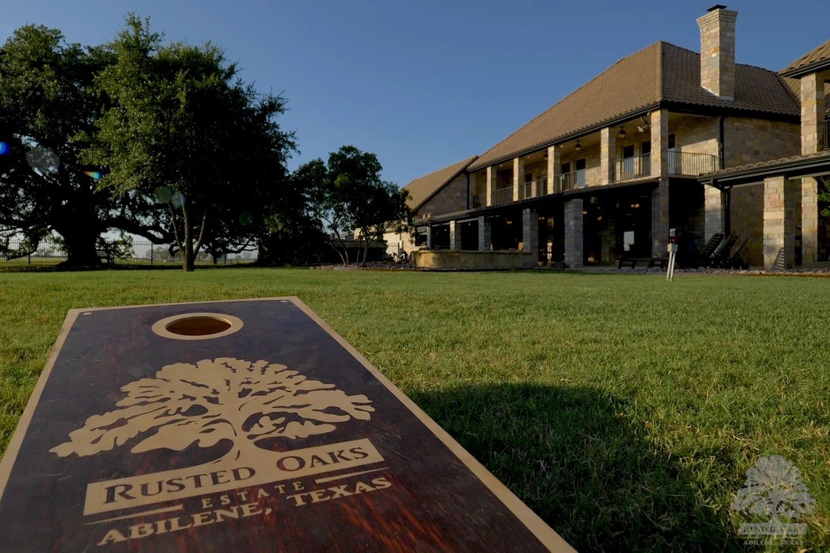 Branded Rusted Oaks cornhole board at golden hour
