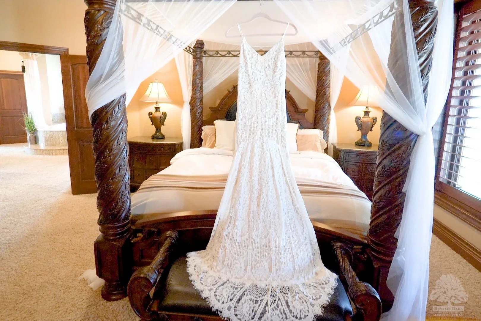 Wedding dress hanging on canopy bed at Rusted Oaks Estate